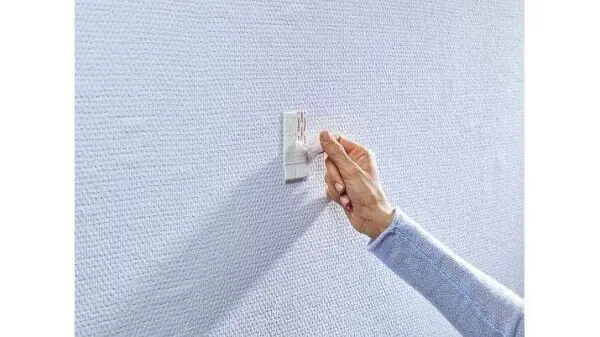 Tesa klæbesøm sat på en væg med tapet