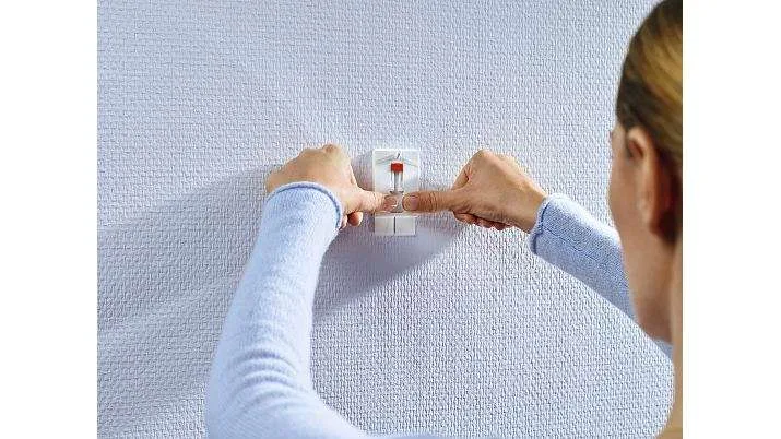 Tesa-2-mont5.jpg Kvinde viser hvordan Tesa klæbesøm fungerer